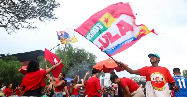 Personas con camisas rojas y banderas con letras referentes a Lula.jpg