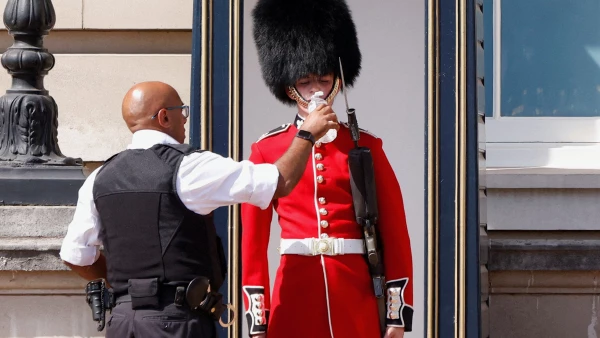 Un miembro de la Guardia de la Reina recibe agua para beber durante el clima cálido, en las afueras del Palacio de Buckingham en Londres, Gran Bretaña.