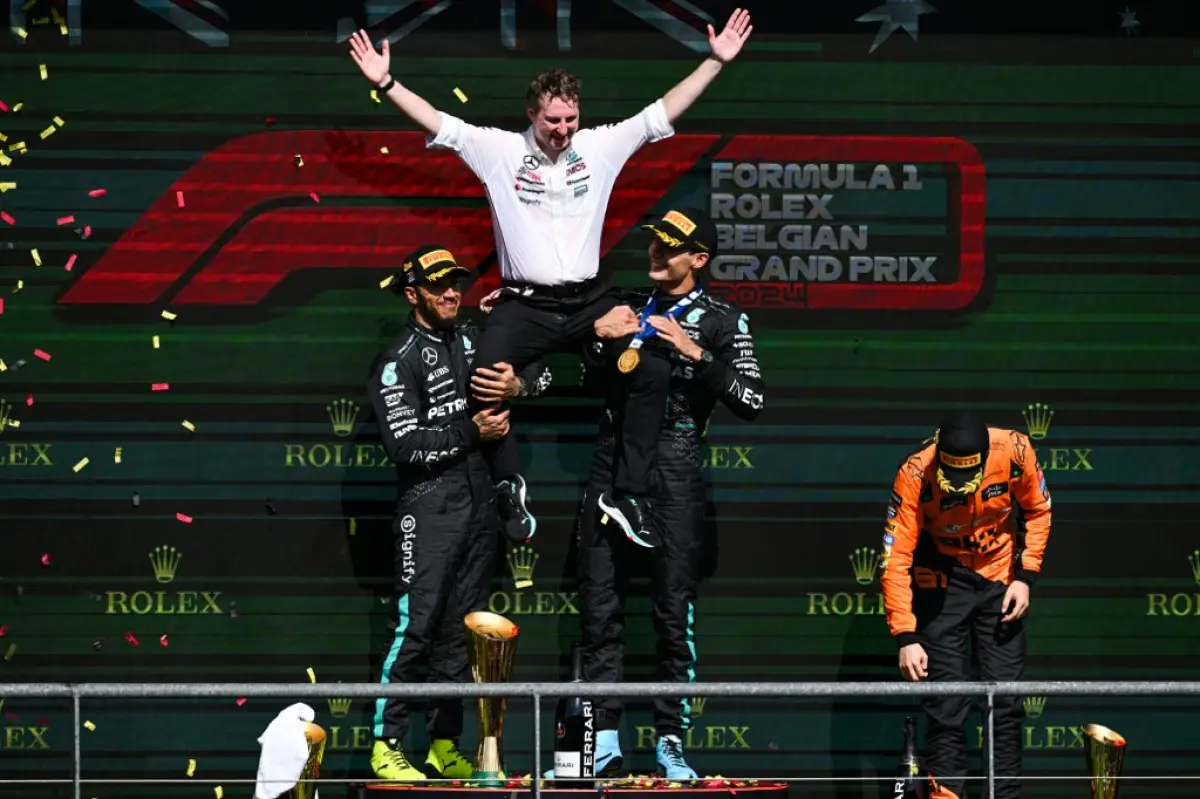 El piloto británico de Mercedes, Lewis Hamilton (i.), y el piloto británico de Mercedes, George Russell (2a R), celebran con el gerente de estrategia de Mercedes, Joe Mc Millan (C) después de ganar el Gran Premio de Fórmula 1 de Bélgica en el Circuito Spa-Francorchamps en Spa el 28 de julio de 2024.
