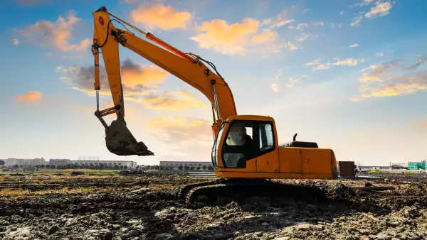 excavator in construction site on sunset sky