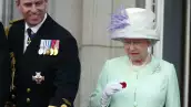 La reina Isabel II sostiene una amapola caída de una bomba Lancaster mientras está de pie junto al príncipe Andrés en el balcón del Palacio de Buckingham durante las celebraciones que marcan el final de la Segunda Guerra Mundial en Londres el 10 de julio de 2005.