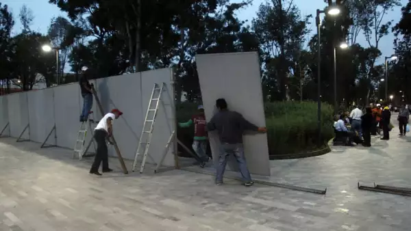 Trabajadores colocan vallas metálicas en la Alameda Central.