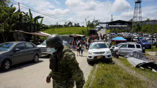 Un soldado cruza la calle mientras los miembros de las familias de los internos esperan afuera de prisión de Santo Domingo de los Tsáchilas en el centro de Ecuador. 