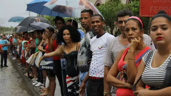 Decenas de cubanos desafiaron las inclemencias del clima y aguardaron el paso de la caravana presidencial en su camino hacia La Habana Vieja