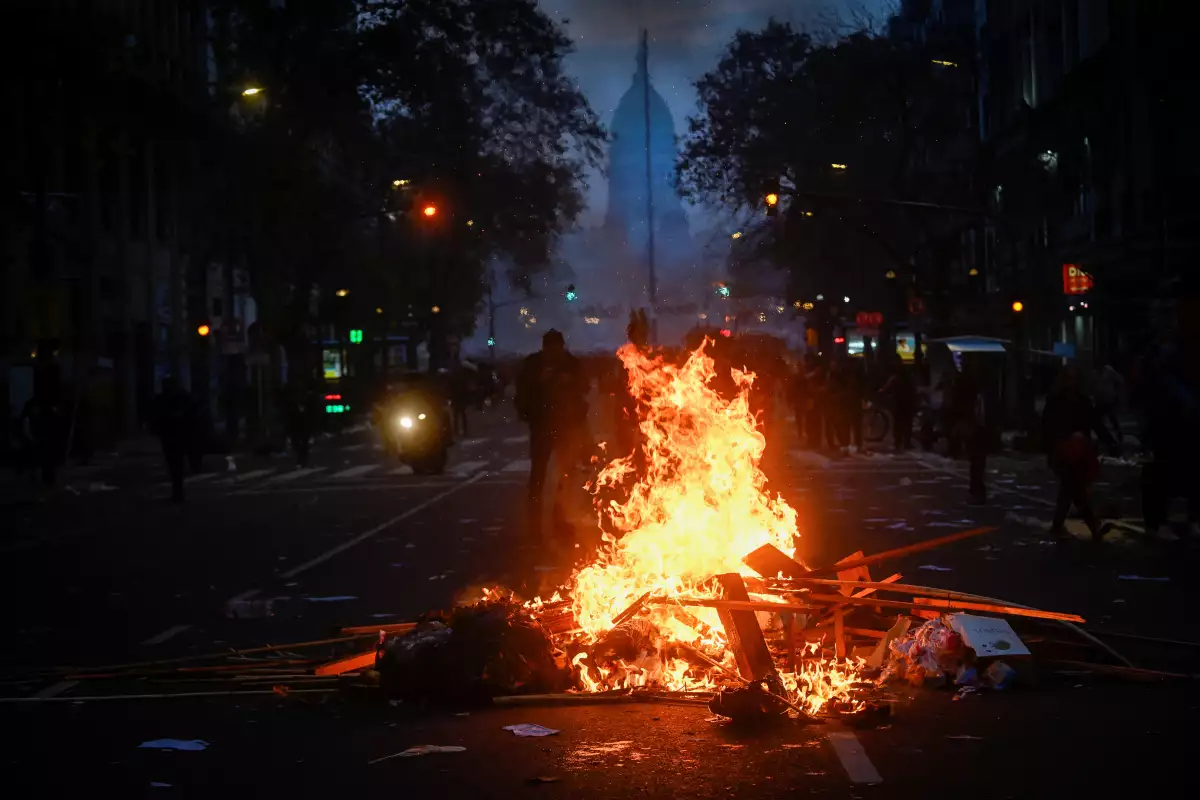 Un fuego arde en una protesta cerca del Congreso Nacional en el día que senadores debaten un paquete de reformas conocido como la "ley ómnibus". 