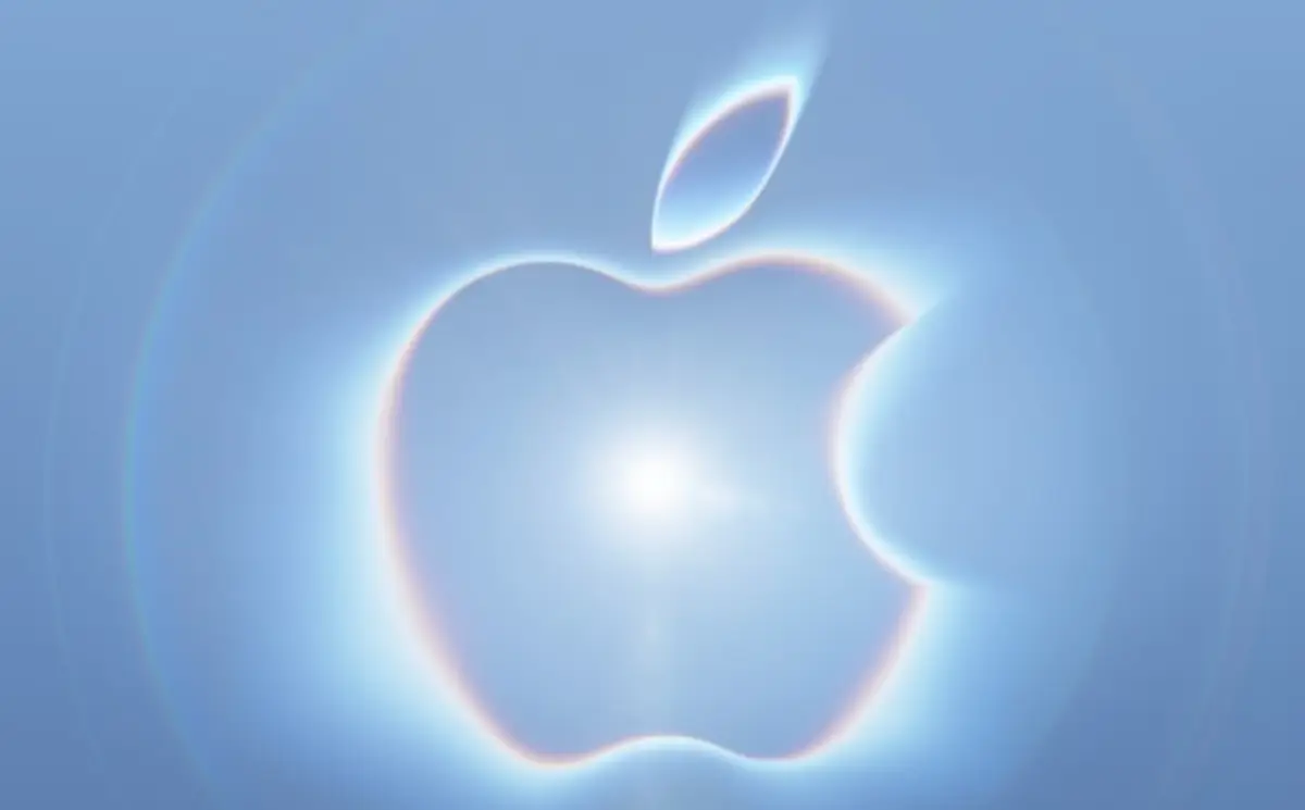 Logo de Apple iluminado por una luz blanca en un fondo color azul.