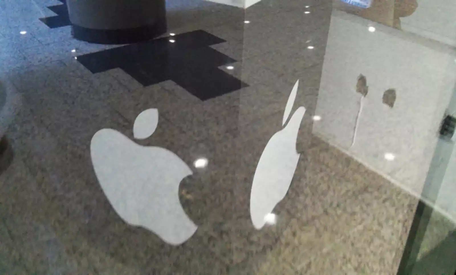 Un cubo con el logo de Apple sostiene publicidad de la tienda.