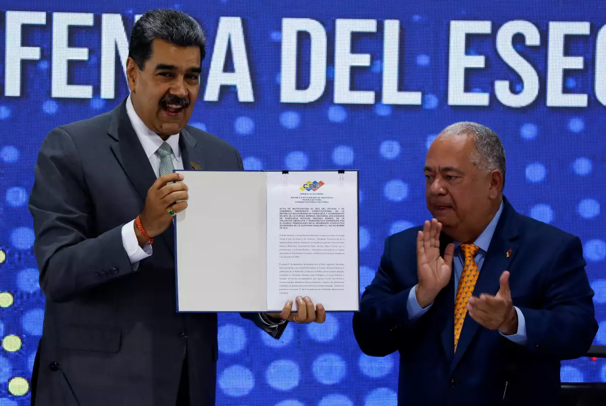 El presidente venezolano Nicolás Maduro tiene el documento que certifica la victoria del referéndum consultivo, junto a Elvis Hidrobo Amoroso, jefe del Consejo Electoral Nacional (CNE) de Venezuela, durante un evento en el CNE después de que los votantes en un referéndum rechazaran la jurisdicción de la Corte Internacional de Justicia (CIJ) sobre la disputa territorial del país con Guyana y respaldaran la creación de un nuevo estado en el potencial Esequibo rico en petróleo, en Caracas, Venezuela, el 4 de diciembre de 2023.