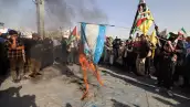 Iraníes queman una bandera israelí durante una protesta en Teheran el 2 de octubre de 2024. 
