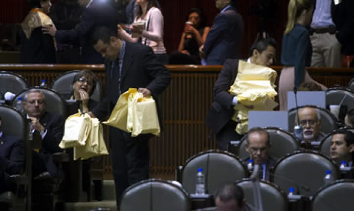 Asistentes llevan comida a los legisladores del PRI durante la sesión (Foto: Cuartoscuro)