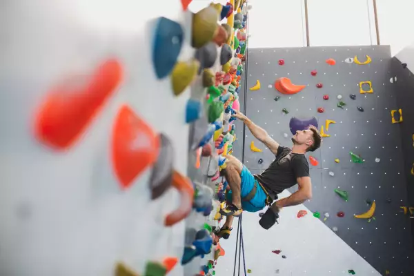 Hombre practicando escalada deportiva en muros.