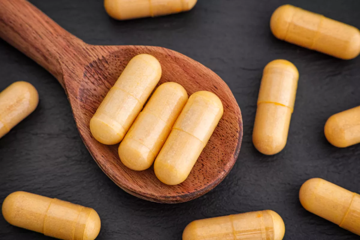 Boswellia capsules in a wooden spoon