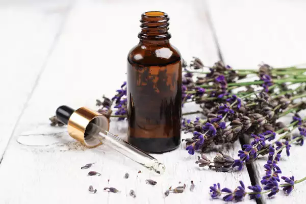 Aceite natural de lavanda sobre una mesa de madera blanca.