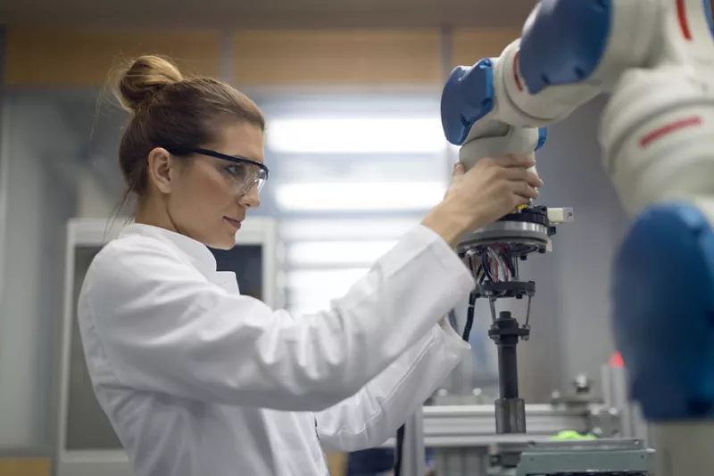 Ingeniera revisando un robot