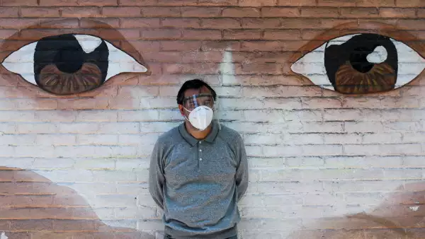 A journalist wearing a protective mask stands by a wall, as the outbreak of the coronavirus disease (COVID-19) continues in Xochimilco, Mexico City