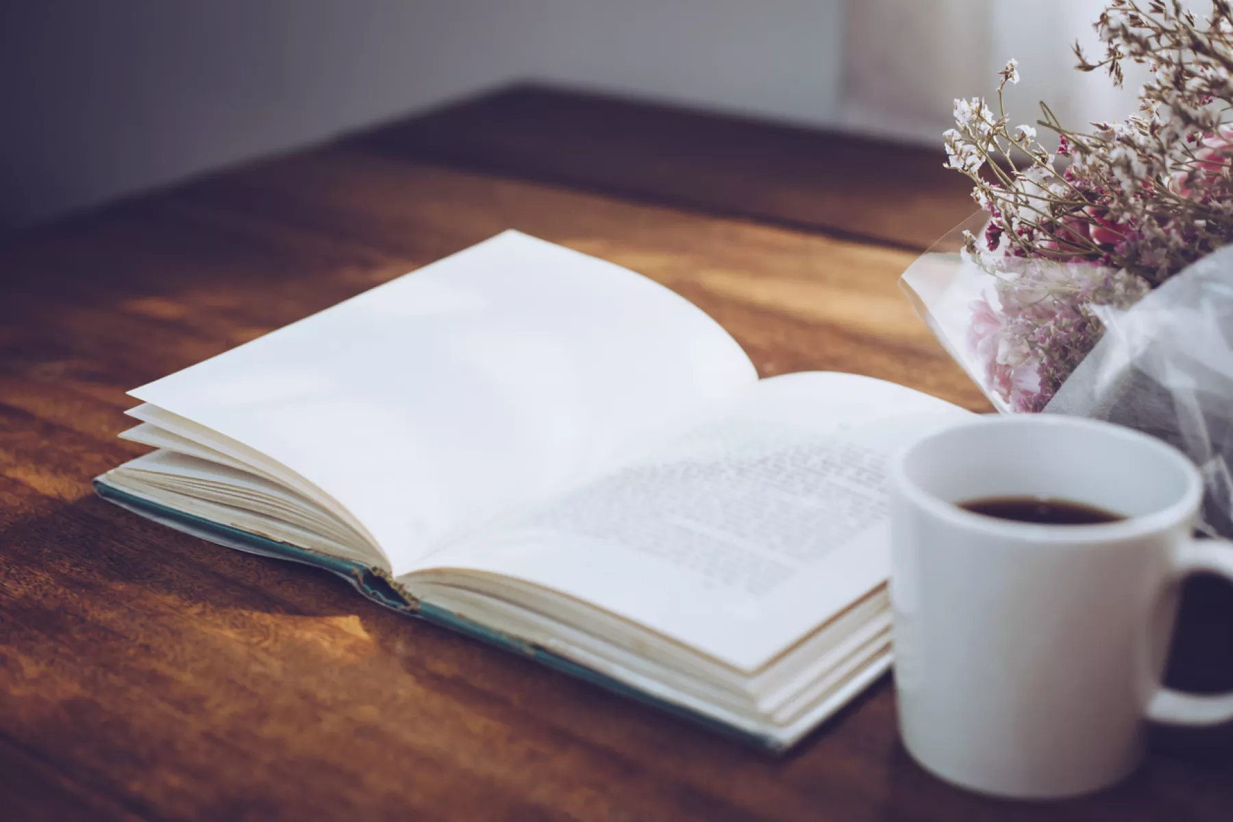  Libro abierto con taza de cafe como acompañante 
