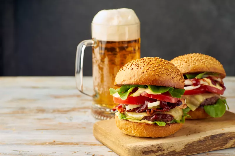 Two big burgers and pint of beer on old wooden table