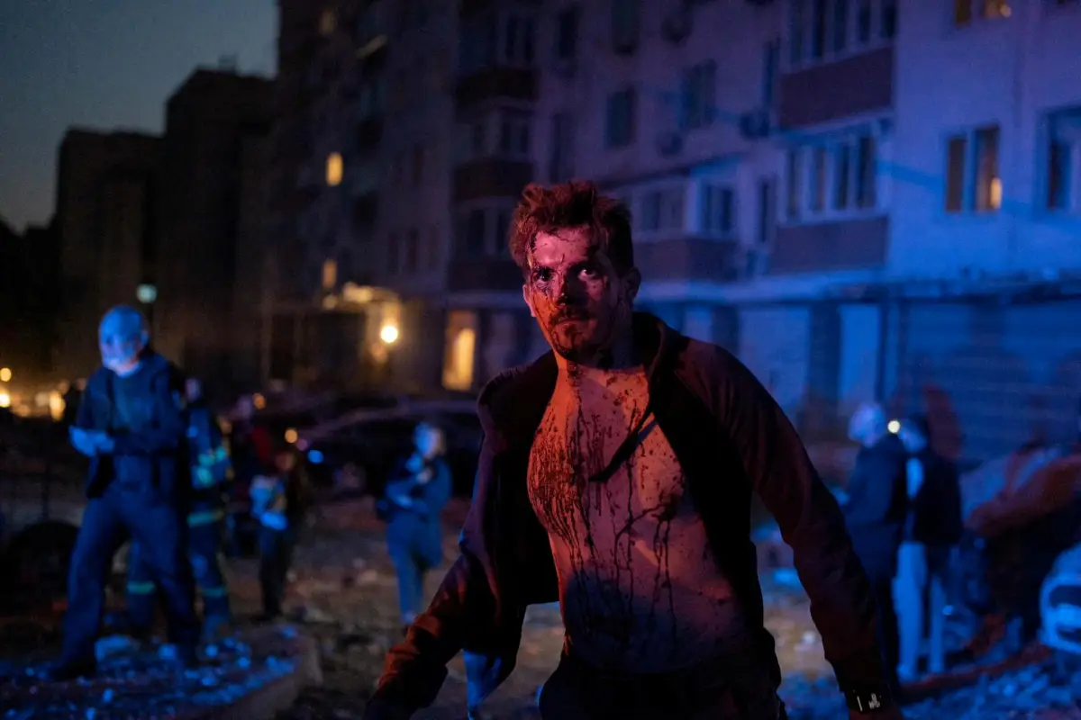 MATERIAL SENSIBLE. ESTA IMAGEN PUEDE OFENDER O PERTURBAR Un hombre herido se encuentra junto a un edificio de apartamentos que fue dañado durante un ataque masivo de aviones no tripulados rusos, en medio del ataque de Rusia contra Ucrania, en Kiev, Ucrania, el 30 de mayo de 2023.