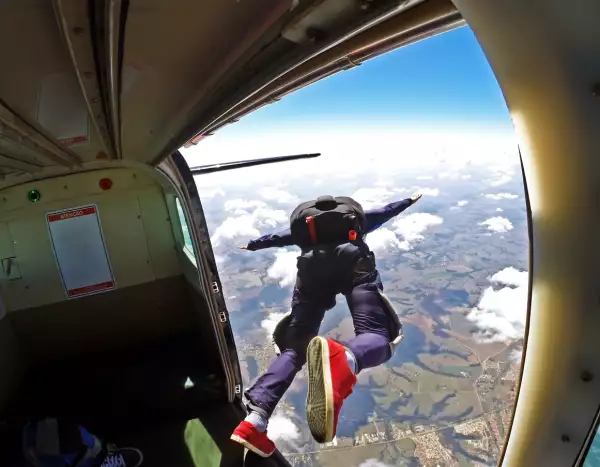 Foto de hombre tirándose de un avión practicando paracaidismo.