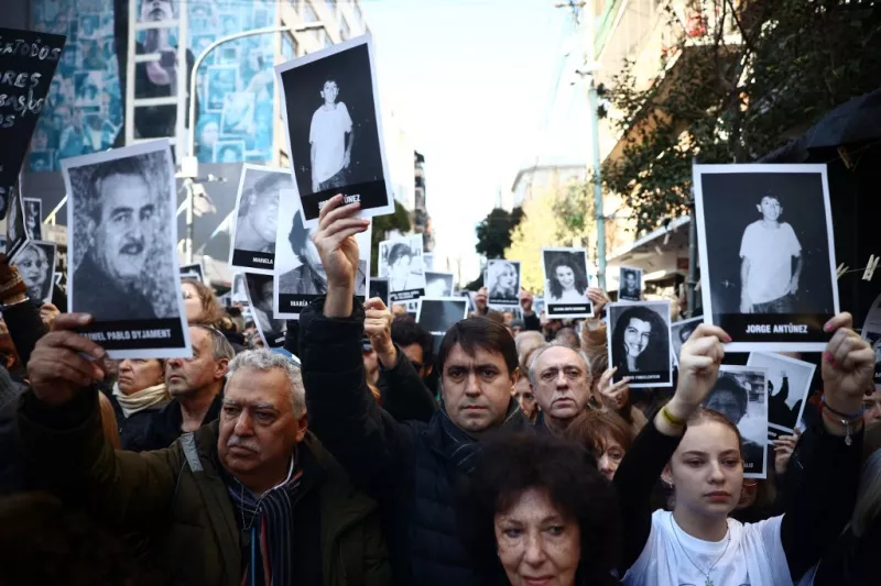 La gente sostiene fotos de las víctimas durante una ceremonia para conmemorar el aniversario del bombardeo de la Asociación Mutua Israelita de Argentina (AMIA) en Buenos Aires el 18 de julio de 2024. 2024 marca el 30 aniversario del bombardeo de 1994 de la AMIA en Buenos Aires, que dejó 85 muertos y más de 300 heridos.