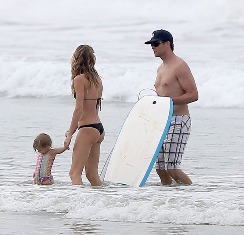 Tom enseña a sus hijos a divertirse en la playa.