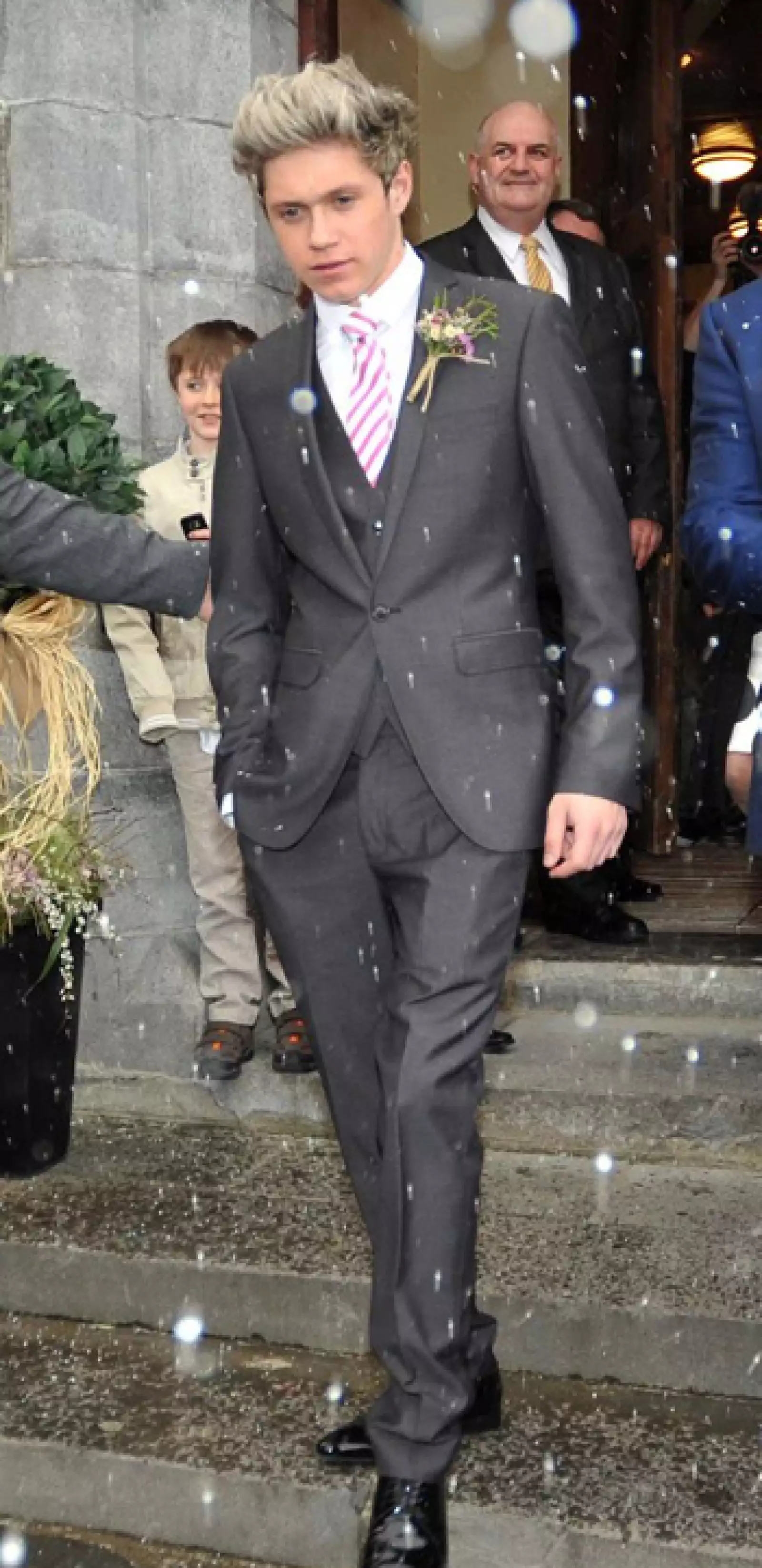 Llevó un traje gris de tres piezas combinado con una corbata a rayas que hacía juego con la del novio.