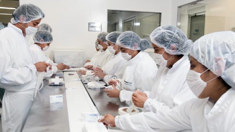 En esta área un operador revisa las cajas que ya salen armadas; otro coloca las etiquetas de seguridad; uno más las acomoda para que les imprima el lote y la fecha de caducidad.