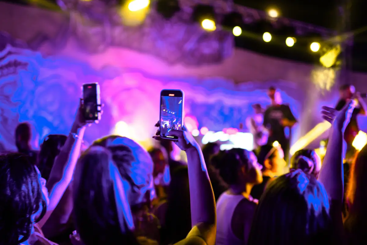 People recording rap group on stage