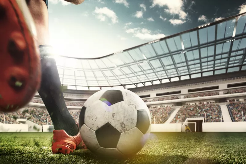 Legs of soccer player kicking the ball