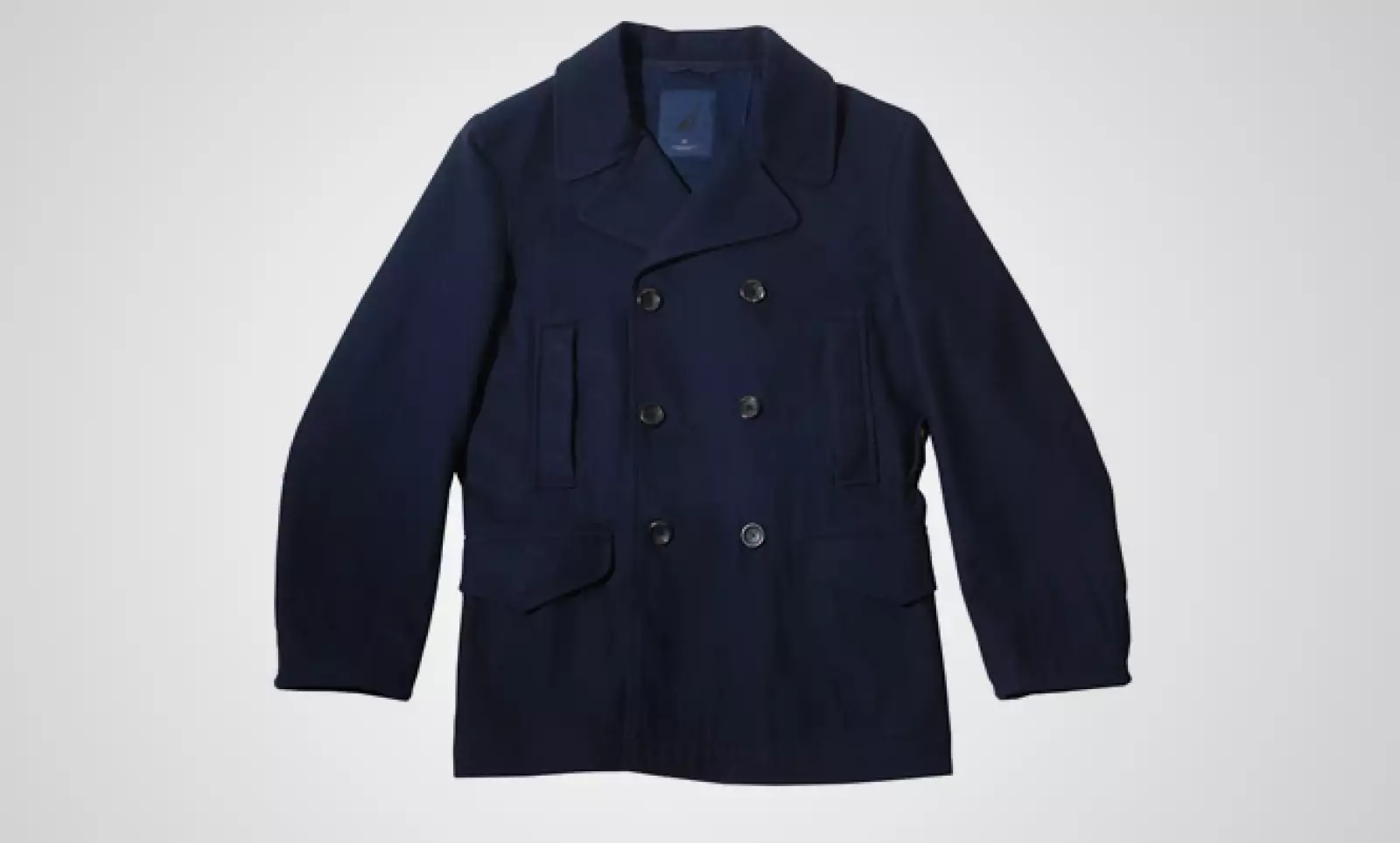 Un abrigo de grandes botones, con el clásico estilo cruzado de la marca, para una protección cálida y elegante, es ideal para combinar con pantalones caqui.