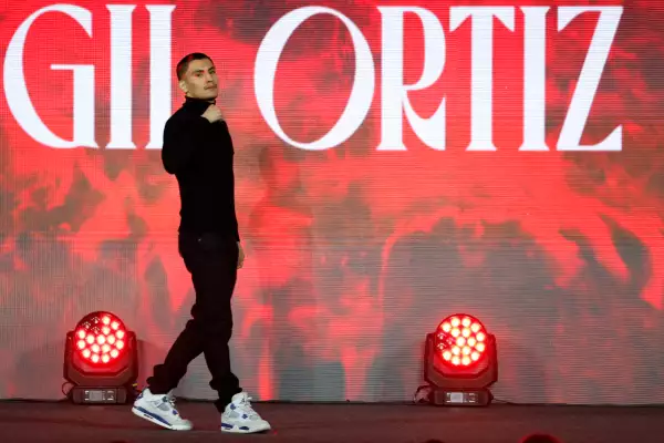 Foto de Ortiz Jr vestido de negro y tenis blancos caminando por el escenario de la presentación de la pelea con el puño a la altura de su cara.