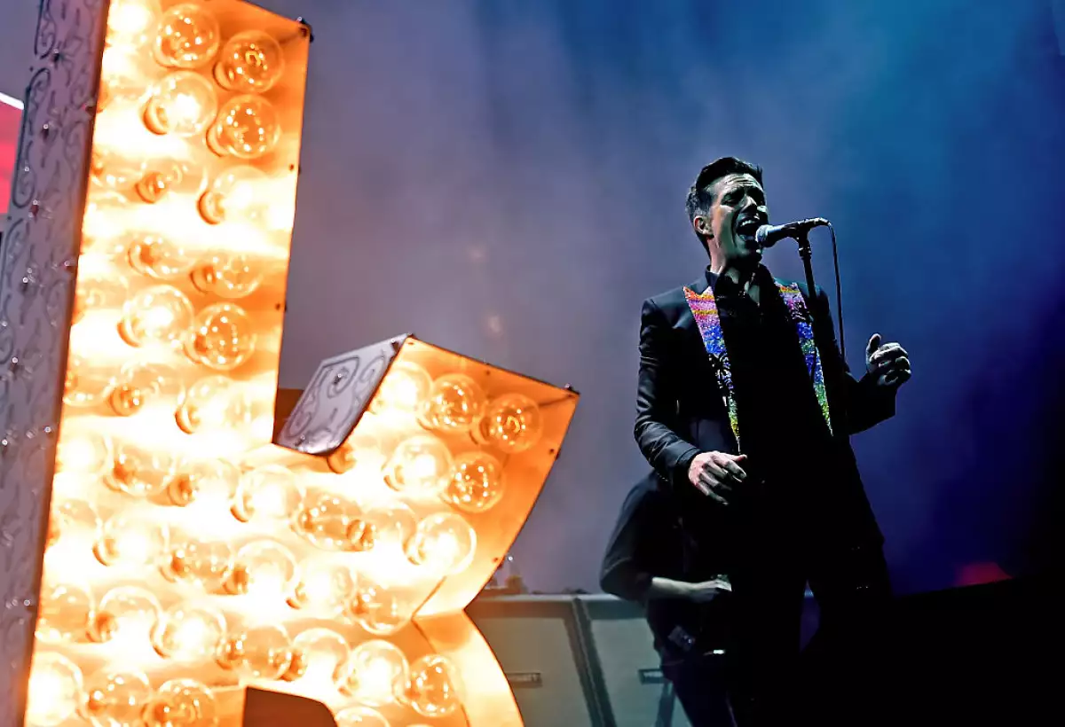 foto de Brandon Flowers en un concierto junto a una K luminosa gigante.