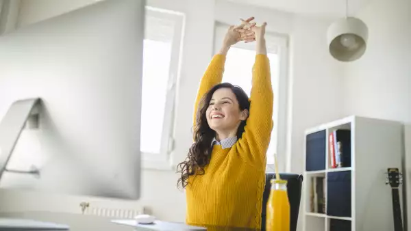 Woman stretching and working at home