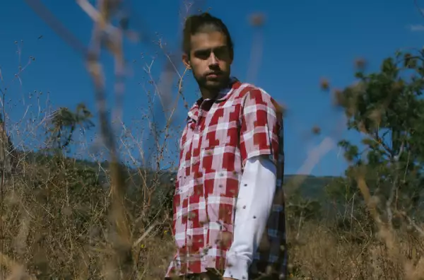 Hombre en el campo con camisa a cuadros rojos de Dockers