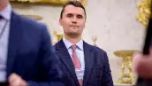 El cofundador de Turning Point USA, Charlie Kirk, se encuentra en la parte trasera de la sala mientras el presidente de los Estados Unidos, Donald Trump, habla durante una ceremonia de juramento para la fiscal interina de los Estados Unidos para Washington, D.C. Jeanine Pirro en la Oficina Oval de la Casa Blanca el 28 de mayo de 2025 en Washington, DC.