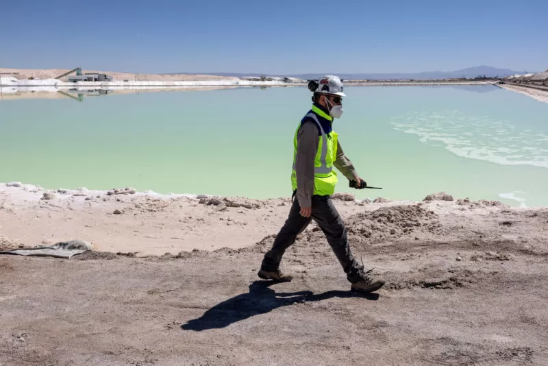 Un supervisor de la mina de litio inspecciona un estanque de evaporación de salmuera rica en litio en el desierto de Atacama el 24 de agosto de 2022 en Salar de Atacama, Chile.