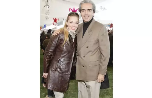 Edith con una chamarra larga de piel en tono café y él mezclo pantalón y saco en tonalidad clara con un sueter negro.