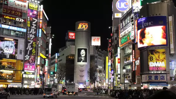 Esquina de una calle con anuncios luminosos.