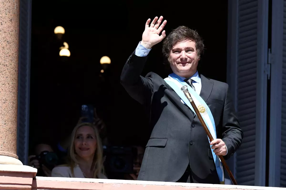 El presidente de Argentina, Javier Milei, saluda a los partidarios desde el balcón de la Casa Rosada, mientras su hermana Karina Milei mira, después de su ceremonia de juramento, en Buenos Aires, Argentina, el 10 de diciembre de 2023