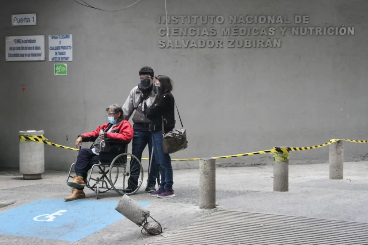 Dos jóvenes junto a un adulto mayor esperan atención a las afueras del Hospital de Nutrición.