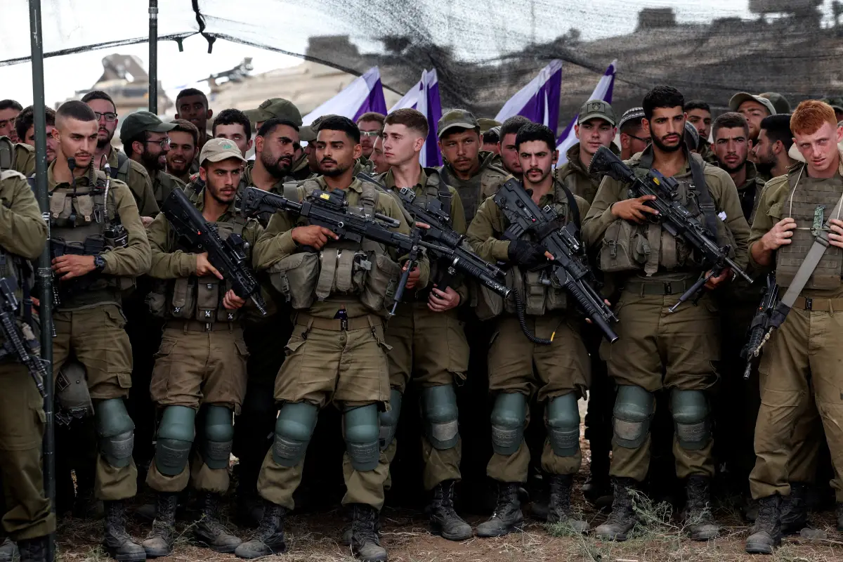 Los soldados israelíes escuchan al ministro de Defensa de Israel, Yoav Gallant, mientras se encuentra con ellos en un campo cerca de la frontera de Israel con la Franja de Gaza, en el sur de Israel, el 19 de octubre de 2023.