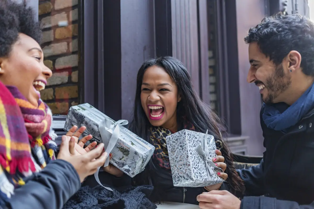 Excited Young Friends Exchanging Christmas Gifts