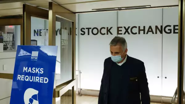 Signo que pide a las personas que usen cubebocas es visto en la Bolsa de Valores de Nueva York.