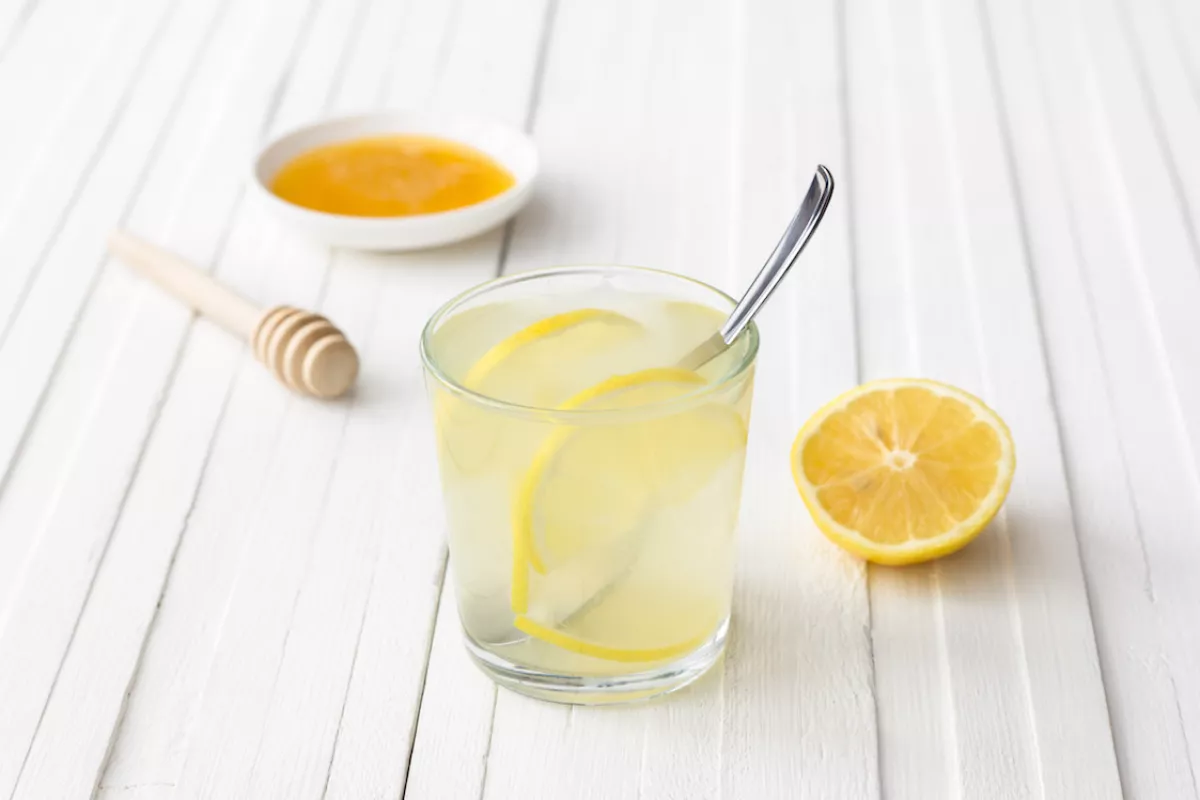 Lemon water in a glass on a white background
