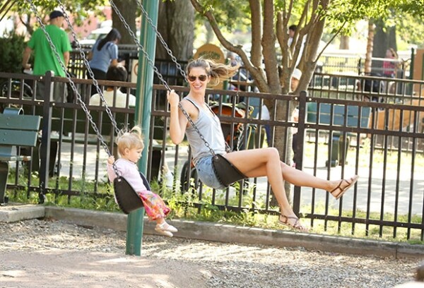 Gisele Bündchen y la pequeña Vivian columpiándose.