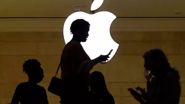 Logo de apple con sombras de personas usando un teléfono
