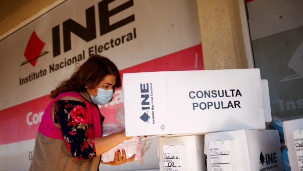 (Trabajadora del Instituto Nacional Electoral, revisa material para realizar una consulta popular)