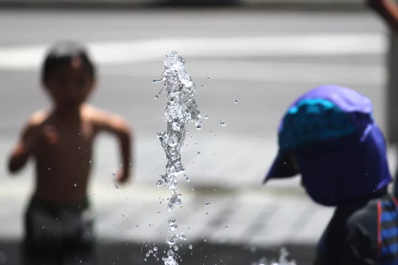 Dos niños juegan en una fuente. 
