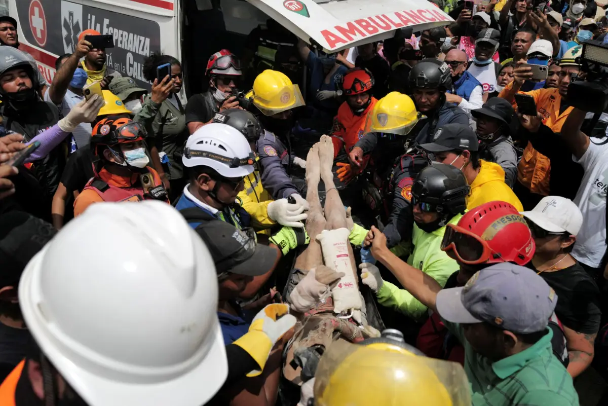 Los rescatistas llevan a una persona después de ser sacado vivo de los escombros de un edificio derrumbado en Caraballeda, estado de La Guaira, Venezuela, el 28 de junio de 2026, después de terremotos.