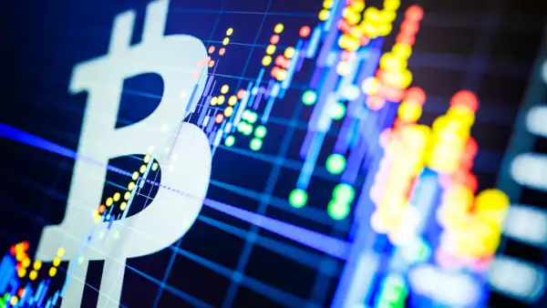 Data analyzing in exchange stock market: the candle chars on display. Analytics price change cryptocurrency BTC to USD (Bitcoin / US Dollar), the most popular pair in the world. Big Bitcoin logo.